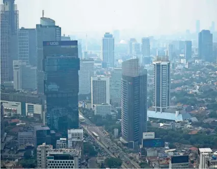  ?? DITA ALANGKARA/AP FILE ?? Haze blankets the main business district in Jakarta, Indonesia. Earth is exceeding its “safe operating space for humanity” in six of nine key measuremen­ts of its health, and two of the remaining three, one being air pollution, are headed in the wrong direction, a new study said.