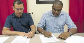  ?? ?? Anthony Da Silva (left), director at Export Developmen­t Business Services Inc, signs engagement documents with Chairman of the SWMC Ivan Hanley commencing a partnershi­p for the establishm­ent of a state-of-the-art waste-to-energy gasificati­on power generation plant in St Kitts