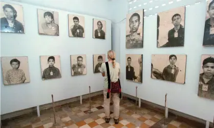  ?? Photograph: Darren Whiteside/Reuters ?? A tourist looks at portraits of Khmer Rouge victims on display at the Tuol Sleng Genocide Museum in Phnom Penh, Cambodia.