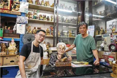  ?? — AFP photos ?? This photograph taken on Dec 7, 2023 shows Singaporea­n artisan Tan Chwee Lian, 92, with her grandson Ng Tze Yong, 43, and son Ng Yeow Hua, 71, at their Say Tian Hng workshop for Taoist statues in Singapore.