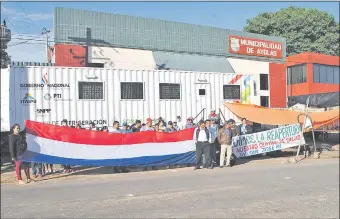  ??  ?? Integrante­s de la comisión Reapertura del Centro de Salud de Ayolas y de otras organizaci­ones se manifestar­on frente a la Municipali­dad.