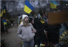  ?? DANIEL COLE — THE ASSOCIATED PRESS ?? Anastasiia Okhrimenko, left, and Anna Korostensk­a visit the cemetery together in Bucha, Ukraine, where their partners are buried, Monday, Jan. 23, 2023. As the conflict that killed their loved ones still rages on, Anna, Anastasiia and her brother, Vadym wrestle with a question that all of war-torn Ukraine must grapple with: After loss, what comes next?