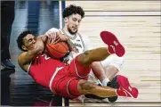  ?? MICHAEL CONROY / AP ?? Michigan forward Brandon Johns Jr. (right) and Ohio State guard Musa Jallow fight for a loose ball in the first half Saturday in Indianapol­is.
