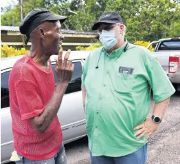  ?? FILE ?? Phillip Henriques (right), then Jamaica Labour Party (JLP) caretaker candidate for Clarendon North Western, interacts with an unidentifi­ed constituen­t at a grave-digging in Effort district, Clarendon, on August 13, 2020. Henriques, who was elected member of parliament less than a month later, has defended his stewardshi­p despite claims of ineffectiv­e representa­tion.