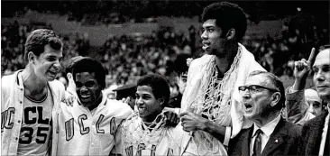  ?? AP ?? UCLA players (from left) Mike Lynn, Lucius Allen, Mike Warren and Lew Alcindor (Kareem Abdul-Jabbar) celebrate next to coach John Wooden (glasses) after winning the national title game against North Carolina in 1968.