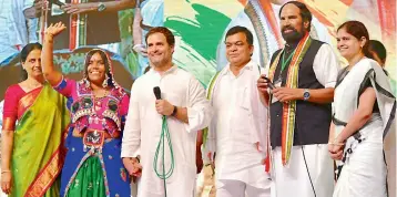  ?? — P. ANIL KUMAR ?? Congress president Rahul Gandhi holds the hand of a Lambada woman, as (from left) former minister Sabita Indra Reddy, former Union minister Balram Naik, TPCC president N. Uttam Kumar Reddy and TPCC Mahila Congress president Nerella Sharada look on, during an interactio­n with women SHGs at Shamshabad on Monday.