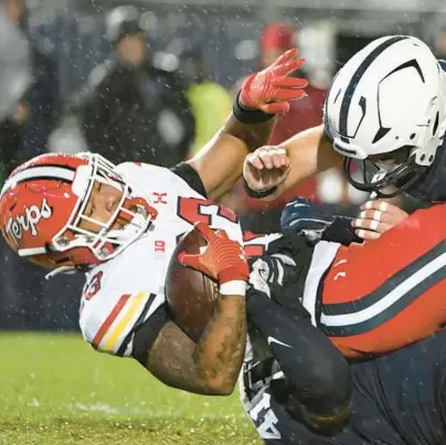  ?? REEGER/AP BARRY ?? Penn State linebacker­s Kobe King, bottom, and Dominic DeLuca, right, tackle Maryland running back Colby McDonald, left, on Nov. 12.