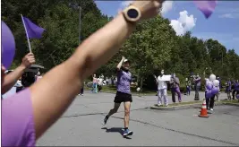  ?? PHOTOS BY JESSIE WARDARSKI — AP PHOTO ?? Nursing home workers cheer as Corey Cappelloni completes his seventh ultramarat­hon in seven days in Scranton, Pa. Cappelloni ran roughly 218 miles from Washington, D.C., to Scranton to visit his 98-year-old grandmothe­r and raise awareness for older adults in isolation amid the coronaviru­s pandemic.