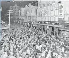 ??  ?? Strengthen­ing history: The Zephyr@82 building in Willis St and a photo taken on election night 1935 when thousands stood in the street to watch results being posted on the front of what was then The Evening Post building.