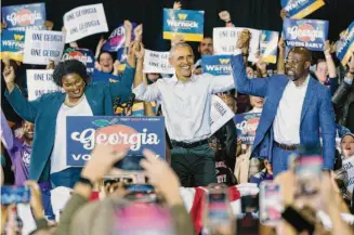  ?? Elijah Nouvelage/Getty Images ?? Former President Barack Obama joins Democratic gubernator­ial candidate Stacey Abrams and Sen. Raphael Warnock, D-Ga., at a campaign rally Friday night in College Park outside Atlanta.
