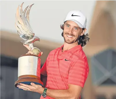  ??  ?? Abu Dhabi champion Tommy Fleetwood gets his hands on the trophy for another year.