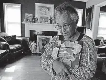  ??  ?? Aster Bekele holds a photo of her son, Senteayeho­u Henry, who was killed last year. Bekele, a retired chemist in Indianapol­is, works with at-risk youths to try and keep them safe.