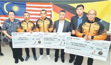  ??  ?? Snowdan (third right) seen with Buda (second left), Malvern (right) and Awang Azizul (third left) who are holding their mock cheques after the press conference at Sarawak Stadium. Also seen are Wee (left) and Ong. — Photo by Chimon Upon