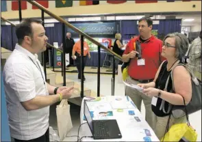  ?? The Sentinel-Record/Richard Rasmussen ?? IN CONCLUSION: Exhibitor Damon Neiser, left, discusses educationa­l technology Wednesday with Lake Hamilton Junior High teachers Suzy Hope, right, and Jeff Cable during the 24th annual Hot Springs Technology Institute at Hot Springs World Class High...