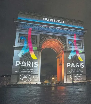  ?? FOTOS: EFE/AP ?? París y Los Angeles, de acuerdo. La decoración del Arco del triunfo se hará realidad para París en 2024. A la derecha, el Memorial Coliseum de Los Angeles la pasada semana, todavía engalanado con la inscripció­n ‘LA 2024’: será en 2028