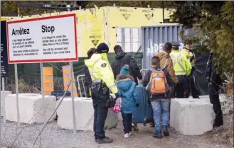  ?? Canadian Press file photo ?? Members of a family claiming to be from Colombia are arrested by RCMP officers as they cross the border into Canada from the United States as asylum seekers near Champlain, N.Y., on April 18. The federal government has spent over $270 million on...