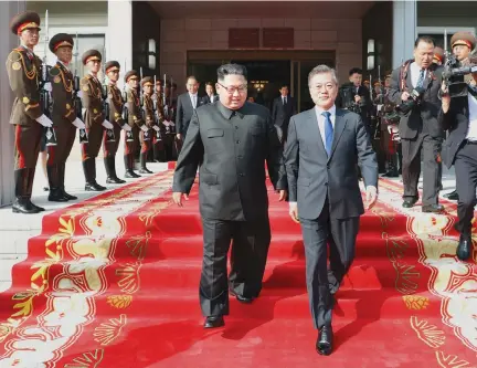  ??  ?? SOUTH KOREAN President Moon Jae-in (R) and North Korean leader Kim Jong Un leave after their summit at the truce village of Panmunjom, North Korea, in this handout picture provided by the Presidenti­al Blue House on May 26.