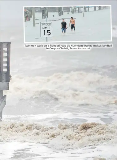  ?? Picture: AP ?? Two men walk on a flooded road as Hurricane Hanna makes landfall in Corpus Christi, Texas.