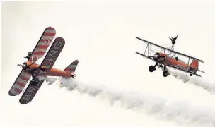  ?? CHRIS WHITEOAK.
AN144429 ?? On a wing and a prayer: The Breitling Wingwalker­s wowed the airshow crowds with their daring display of high altitude acrobatics.