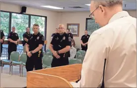  ?? Bryan Perry ?? Officers Ethan Sarrell (left) and Justin Ruth look on during the Aug. 12 City Council meeting as Fort Oglethorpe Police Chief Mike Helton details their heroic efforts that saved two lives.