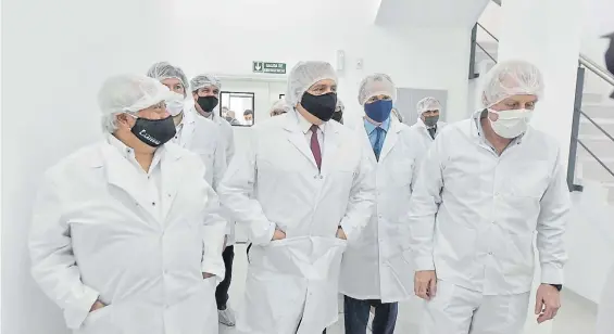  ??  ?? De blanco. Alberto Fernández, con el gobernador entrerrian­o Gustavo Bordet, ayer en una visita a las instalacio­nes de un laboratori­o en Paraná.