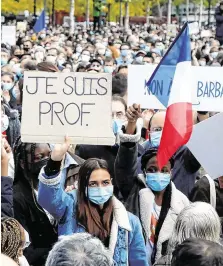  ?? PHOTO: REUTERS/ CHARLES PLATIAU ?? Solidarity: People gather at the Place de la Republique in Paris yesterday, to pay tribute to Samuel Paty, the French teacher who was beheaded on Friday.