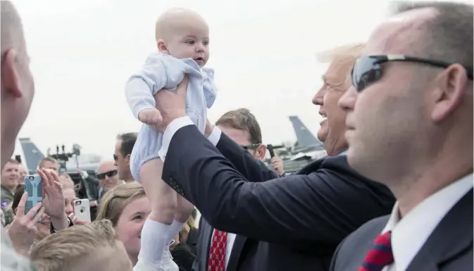  ??  ?? WISCONSIN: US President Donald Trump holds a baby while greeting well wishers after arriving on Air Force One at General Mitchell Internatio­nal Airport. — AFP
