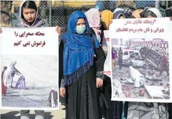  ?? FOTO: RAHMAT GU/DPA ?? Afghanisch­e Aktivistin­nen protestier­en mit Transparen­ten gegen das Abkommen der USA mit den Taliban. Auf den Plakaten ist sinngemäß zu lesen: „Wir dürfen die Gerichtsve­rhandlunge­n nicht vergessen“und „Die Taliban-Gruppe ist die Ursache von Zerstörung und Völkermord“.