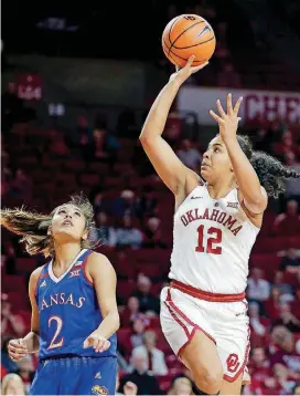  ?? [PHOTO BY BRYAN TERRY, THE OKLAHOMAN] ?? Oklahoma’s Gileysa Penzo (12) shoots a basket beside Kansas’ Brianna Osorio (2) during the Sooners game against the Jayhawks Wednesday night at Lloyd Noble Center in Norman.