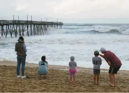  ?? MARK WILSON/GETTY ?? People look out at the Avalon Pier that was damaged by Hurricane Dorian on Sept. 6, 2019, in Kill Devil Hills, North Carolina. Dorian passed Charleston, South Carolina, as a category 3 storm and then hit the Outer Banks as a category 1 storm.