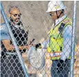  ?? ?? A policeman takes a bag containing the noose at the Chicago building site