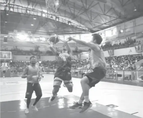  ??  ?? UV's Gileant Delator slices through USC defenders during their APUG basketball match yesterday at the Cebu Coliseum. UV won, 92-78.