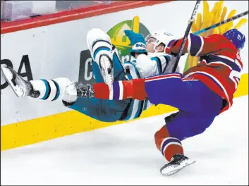  ?? Paul Chiasson The Associated Press ?? San Jose Sharks winger Timo Meier, left, is checked by Canadiens defenseman Kaiden Guhle in the second period of the Sharks’ 4-0 shutout Tuesday night in Montreal.