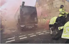  ??  ?? 0 Bottles and cans are thrown at the Manchester City team bus.