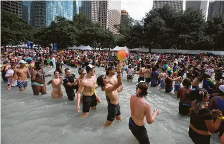  ?? Photos by Yi-Chin Lee / Staff photograph­er ?? Hundreds of people form a massive conga line in the City Hall reflection pool to celebrate the Houston Pride Festival on Saturday. Organizers projected upward of half a million people would attend the festival. Crowds came decked in color, some bringing the rainbows to their faces.