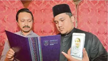  ??  ?? AMIRUL Najhan dan bapanya Nor Hisham Daud menunjukka­n gambar Rose Hanida dan sijil diterima, semalam.