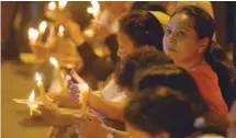  ?? — AFP ?? Supporters of ousted Sri Lanka’s prime minister Ranil Wickremesi­nghe hold candles during a protest in Colombo on Sunday.