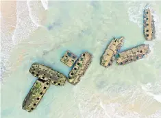  ??  ?? Remains of the temporary Mulberry harbour on the shore of Arromanche­s in Normandy