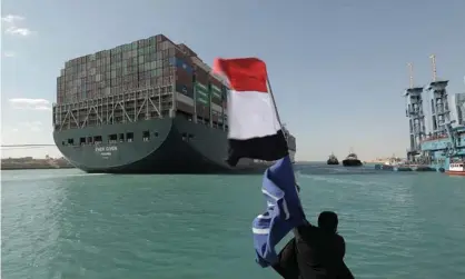  ?? Photograph: Suez Canal Authority/Getty ?? A man waves the Egyptian flag after the Ever Given was dislodged. It caused an estimated £7bn daily loss in trade and cost the Suez canal up to £10.9m a day.