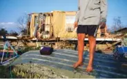  ?? AP FILE PHOTO/JOHN LOCHER ?? Aiden Locobon stands on a boat near the remnants of his family’s home destroyed by Hurricane Ida, in Dulac, La.