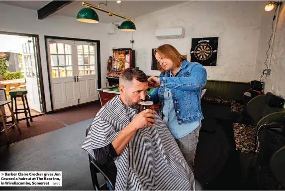  ?? SWNS ?? Barber Claire Crocker gives Jon Coward a haircut at The Bear Inn, in Wiveliscom­be, Somerset