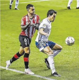  ?? CARLOS GOL-ROIG ?? Zapater protege el balón ante la llegada de Nano Mesa.