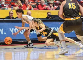  ?? ROBERTO E. ROSALES/JOURNAL ?? UNM’s LaTora Duff, left, outhustles Wyoming’s Tommi Olson (24) for a loose ball during Thursday night’s game at the Pit. Duff and the Lobos host San Jose State on Saturday.