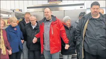  ?? AMY LAVALLEY/POST-TRIBUNE ?? Ben Polhemus, pastor of community engagement at Liberty Bible Church, leads members of the community in a brief prayer during a Thursday ribbon-cutting for Hilltop Neighborho­od House’s new food pantry in Valparaiso.