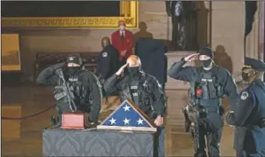  ?? (The New York Times /Anna Moneymaker) ?? Capitol Police officers pay respects to the late U.S. Capitol Police officer Brian Sicknick as an urn with his cremated remains lies in honor on a black-draped table at the center of the Capitol Rotunda in Washington. On Friday, The Associated Press reported on stories circulatin­g online incorrectl­y asserting Fox News entirely ignored the Feb. 2 ceremony in the Capitol Rotunda.