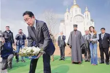  ?? Iori Sagisawa/Associated Press ?? Japanese Prime Minister Fumio Kishida lays flowers for war victims at a church in Bucha, a town outside Kyiv.