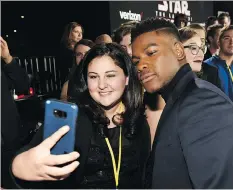  ?? THE ASSOCIATED PRESS ?? The Last Jedi actor John Boyega poses with Olivia Sava, 14, at the première of the film in Los Angeles. Sava, who has a form of leukemia, was among seven teens with life-threatenin­g illnesses who had their Star Wars wishes granted.