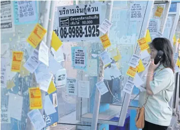  ?? PANUMAS SANGUANWON­G ?? Advertisem­ents for personal loans are seen on a telephone booth in Bangkok. The government launched picofinanc­e to enable lower-income earners to stay away from loan sharks.
