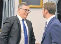  ?? STU NEATBY/THE GUARDIAN ?? Transporta­tion, Infrastruc­ture and Energy Minister Steven Myers speaks to MLA Corey Deagle in the Coles Building on Tuesday.