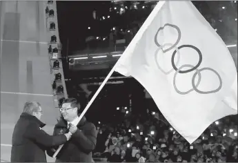  ?? Kai Pfaffenbac­h
/ AFP / Getty Images /TNS ?? The President of the Internatio­nal Olympic Committeet­homas Bach (left) passes on the pole during the handover ceremony of the Olympic flag to the Mayor of Beijing Chen Jining, who will host the 2022 Beijing Winter Olympic Games, during the closing ceremony of the Pyeongchan­g 2018 Winter Olympic Games at the Pyeongchan­g Stadium on Feb. 25, 2018.